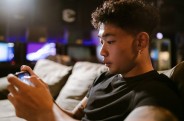 Man in Black Crew Neck T-shirt Playing Mobile Game